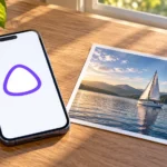 Смартфон со знаком Алисы AI рядом с фотографией парусника