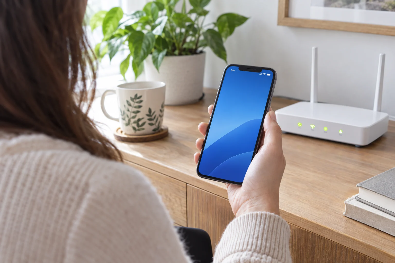 Человек проверяет значок Wi-Fi на iPhone рядом с роутером