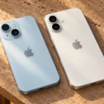 Два iPhone со светлыми спинками и логотипами Apple лежат рядом перед переносом данных
