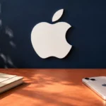Логотип Apple рядом с iPhone и блокнотом